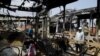 People look at burned-out buses in Lagos, Oct. 24, 2020. Nigeria's president says 51 civilians have been killed in unrest following days of peaceful protests over police abuses, and he blames "hooliganism" for the violence.