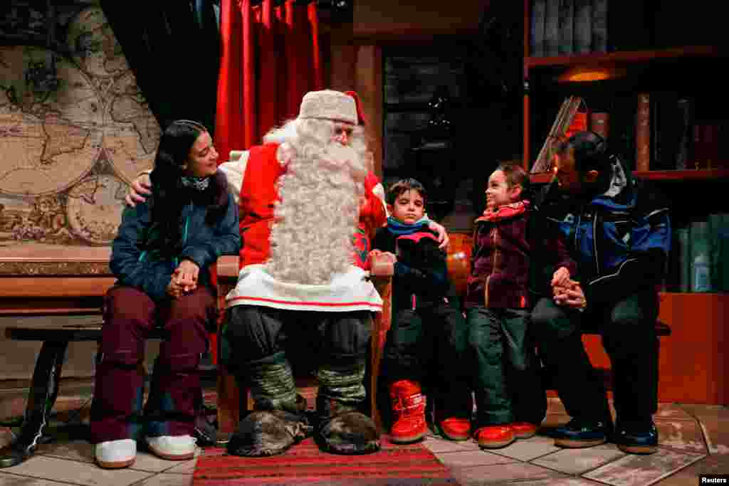 Children around the world visit Santa. In this image, Santa Claus talks to the Caballero family from Itay at Santa Claus' Village.
