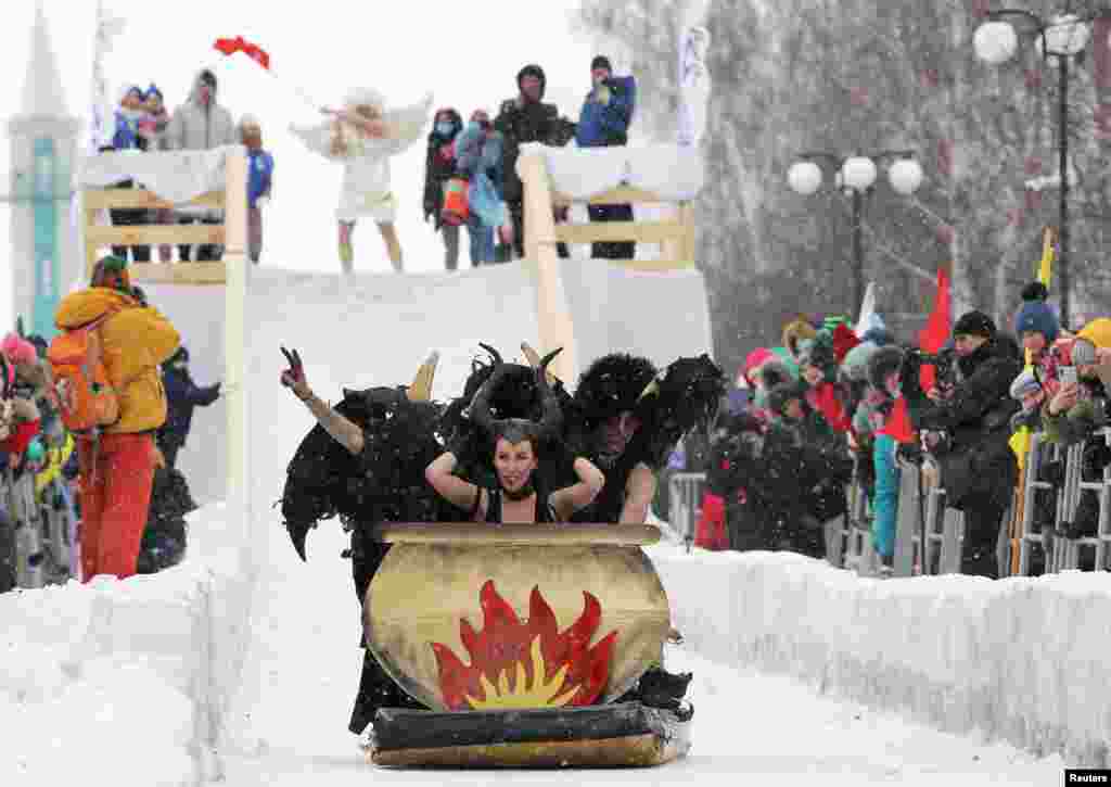 Participants ride down a slope during the "Sunnyfest" festival of unusual sledges in the town of Mamadysh in the Republic of Tatarstan, Russia, Feb. 6, 2021.