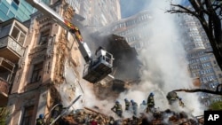 Wafanyakazi wa zima moto washughulika kuzima moto kwenye majengo mjini Kyiv, baada ya shambulio la ndege isiyo na rubani, Oktoba 17, 2022. Picha ya AP