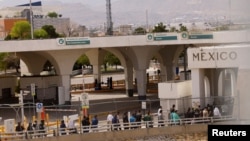 Migrantes venezolanos, expulsados de EEUU y enviados de regreso a México bajo el Título 42, caminan hacia México a través del puente fronterizo internacional Lerdo-Stanton, en Ciudad Juárez, México, el 14 de octubre de 2022. 
