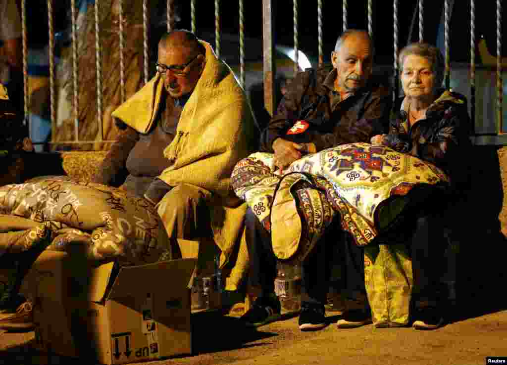 Warga menyelimuti diri untuk bersiap tidur di tempat terbuka menyusul gempa di Amatrice, Italia tengah (24/8). (Reuters/Stefano Rellandini) 