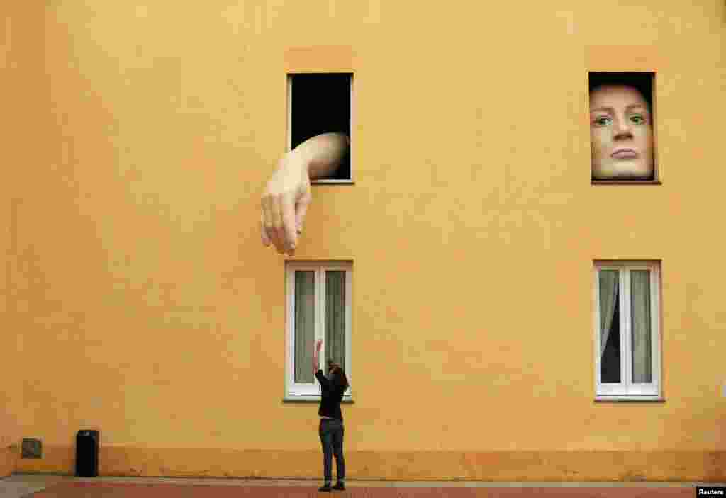 A woman takes pictures of art installation "Alice" by Spanish artist Cristina Lucas in the Andalusian Center of Contemporary Art in the Andalusian capital of Seville, southern Spain, April 10, 2013.