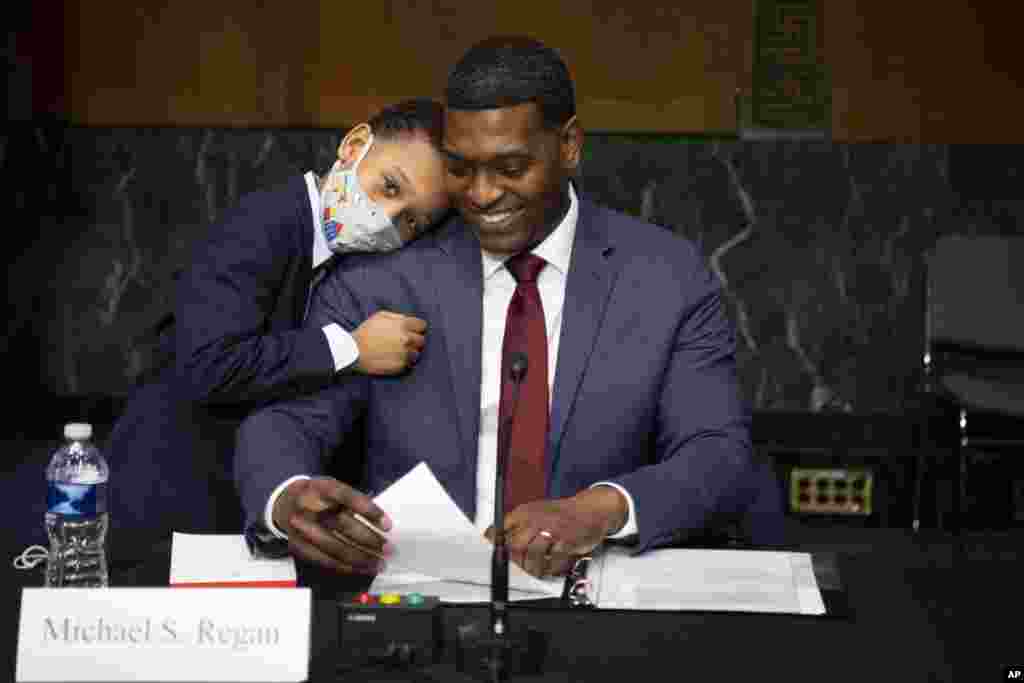 Administrator of the Environmental Protection Agency nominee Michael Regan is hugged by his son, Matthew, after his confirmation hearing before the Senate Environment and Public Works committee on Capitol Hill in Washington, Feb. 3, 2021.