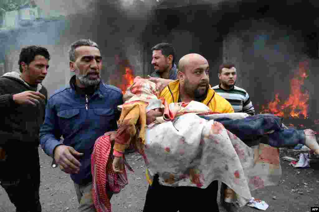 Civilians carry a young victim at the scene of an explosion in the town of Azaz in the rebel-controlled northern countryside of Syria's Aleppo province.