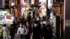 People wearing protective masks, amid the coronavirus disease (COVID-19) outbreak, make their way at a shopping district in Tokyo, Japan, July 28, 2021.