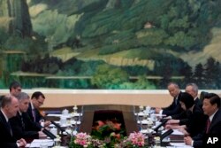 U.S. National Security Adviser Tom Donilon, left, and Chinese President Xi Jinping, right, during their meeting in Beijing, May 27, 2013.