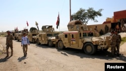 Vehículos militares iraquíes y combatientes chiitas se reunen en la represa Udhaim, al norte de Bagdad, el 1 de marzo, de 2015. 
