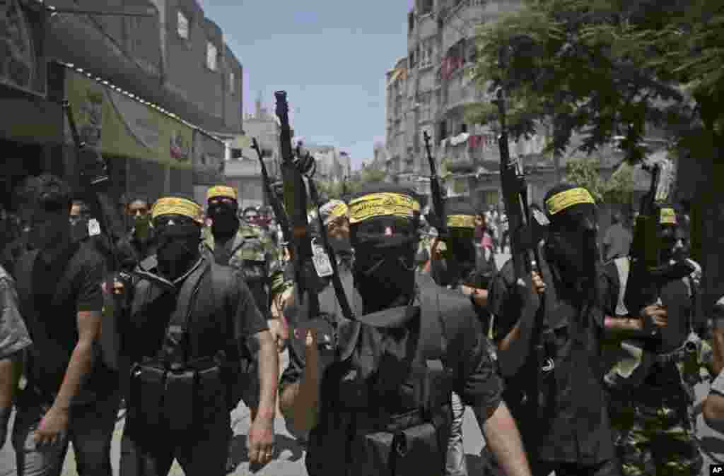 Kelompok militan bertopeng berbaris dengan membawa senjata saat menghadiri pemakaman dua orang militah Fatah, Marwan Sleem dan Mazin Al-Jarba, yang tewas dalam serangan udara Israel, di kamp pengungsi Bureij, Jalur Gaza tengah (7/7).