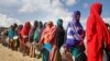 Women who fled drought queue to receive food distributed by local volunteers at a camp for displaced persons in the Daynile neighborhood on the outskirts of Mogadishu, in Somalia, May 18, 2019. 