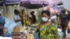 FILE - A woman wearing a face mask to protect against the novel coronavirus walks on a street in Lagos, Nigeria , Dec. 31, 2020. 