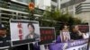 香港民主抗議者舉著銅鑼灣書店老闆桂民海（左）和李波（右）的肖像（2016年1月19日）