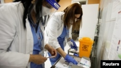 Zdravstvene radnice pripremaju doze vakcine protiv kovida 19 proizvođača Sputnjik V, u Podgorici, Crna Gora, 22. februara 2021. (Foto: Rojters, Stevo Vasiljević)