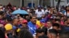 El presidente venezolano, Nicolás Maduro, saluda a jóvenes partidarios que marchan contra las sanciones impuestas por Estados Unidos a Venezuela, en Caracas, el viernes 17 de mayo de 2024.