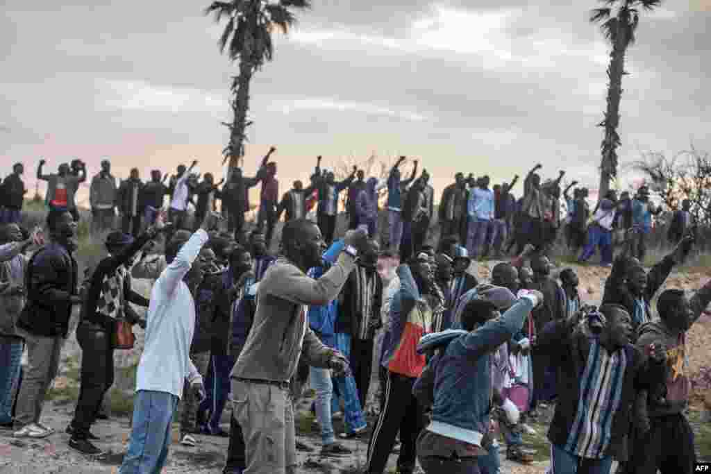 Would-be immigrants of the Center for Temporary Stay of Immigrants (CETI) cheer other ones who want to cross the fence near Beni Enza, into the north African Spanish enclave of Melilla. Several hundred people attempted to cross into the Spanish city, which lies on the northern tip of Morocco.