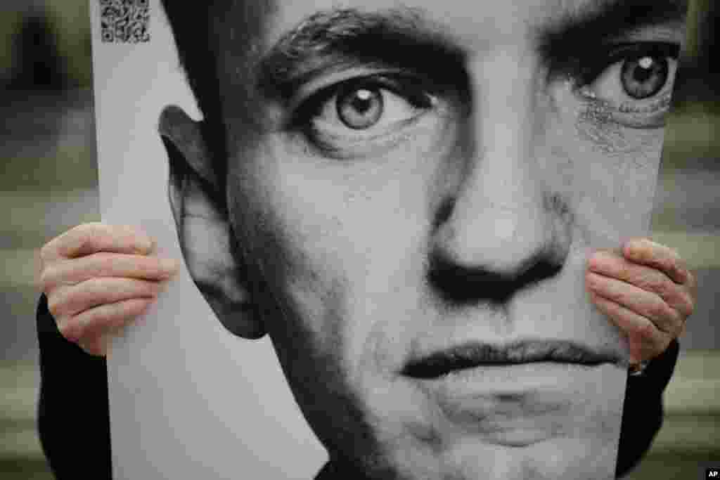 A man holds a poster with a portrait of opposition leader Alexey Navalny during a protest in front of the Russian embassy in Berlin, Germany. Navalny, who crusaded against official corruption and staged massive anti-Kremlin protests as President Vladimir Putin’s fiercest foe, died Friday in the Arctic penal colony where he was serving a 19-year sentence, Russia’s prison agency said.