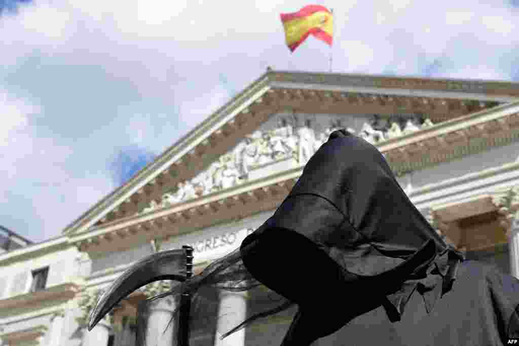 A protester dressed as Death demonstrates against a law legalizing euthanasia, as Parliament gives final approval to bill decriminalizing euthanasia and physician-assisted suicide, in Madrid.