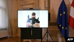 На экране фотография мужчины, задержанного по подозрению в организации теракта на концерте Тейлор Свифт в Вене. МИД Австрии, Вена, 8 августа 2024 года (Фото: ROLAND SCHLAGER / APA / AFP) /
