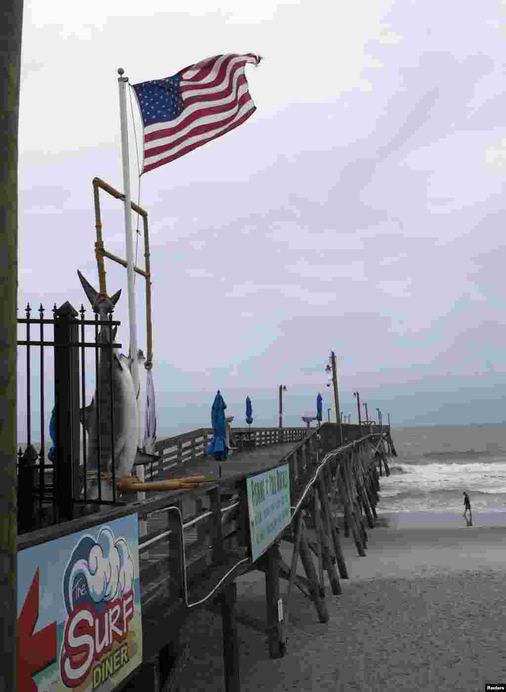 Seorang pria di Pantai Surfside, South Carolina, sebelum hujan dan bagian luar Badai Arthur bergerak mendekat (3/7). (Reuters/Randall Hill)