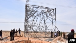 Nigerian security forces are seen on the site of a sabotage attack allegedly perpetrated by Boko Haram against electical infrastructures on the outskirts of Maiduguri on Feb. 12, 2021.