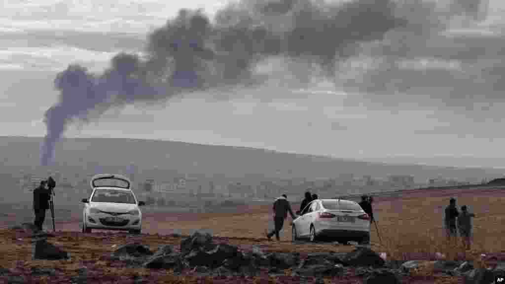 Truyền thông theo dõi trận chiến ở Kobani trên một ngọn đồi ở ngoại ô Suruc, biên giới Thổ Nhĩ Kỳ-Syria, ngày 19/10/2014.
