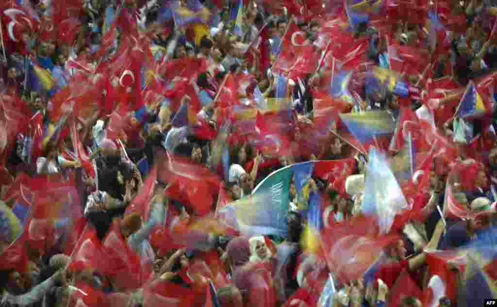 Supporters wave flags as Turkish President speaks during a pre-election rally in Sarajevo, Bosnia.