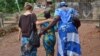 Cora, a trafficking survivor, walks with her case manager and social worker in Sierra Leone. Credit: WHI