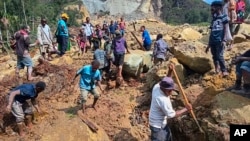পাপুয়া নিউ গিনির ইয়াম্বালি গ্রামে ভূমিধ্বসের পর উদ্ধারকারীরা মাটি-পাথর খুঁড়ে কাজ করছেন। ফটোঃ ২৬ মে, ২০২৪। 