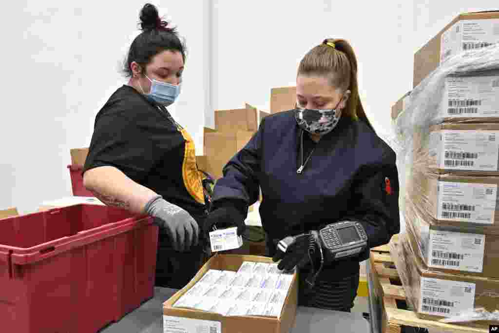 Employees with the McKesson Corporation scan a box of the Johnson & Johnson COVID-19 vaccine while filling an order at their shipping facility in Shepherdsville, Kentucky. 
