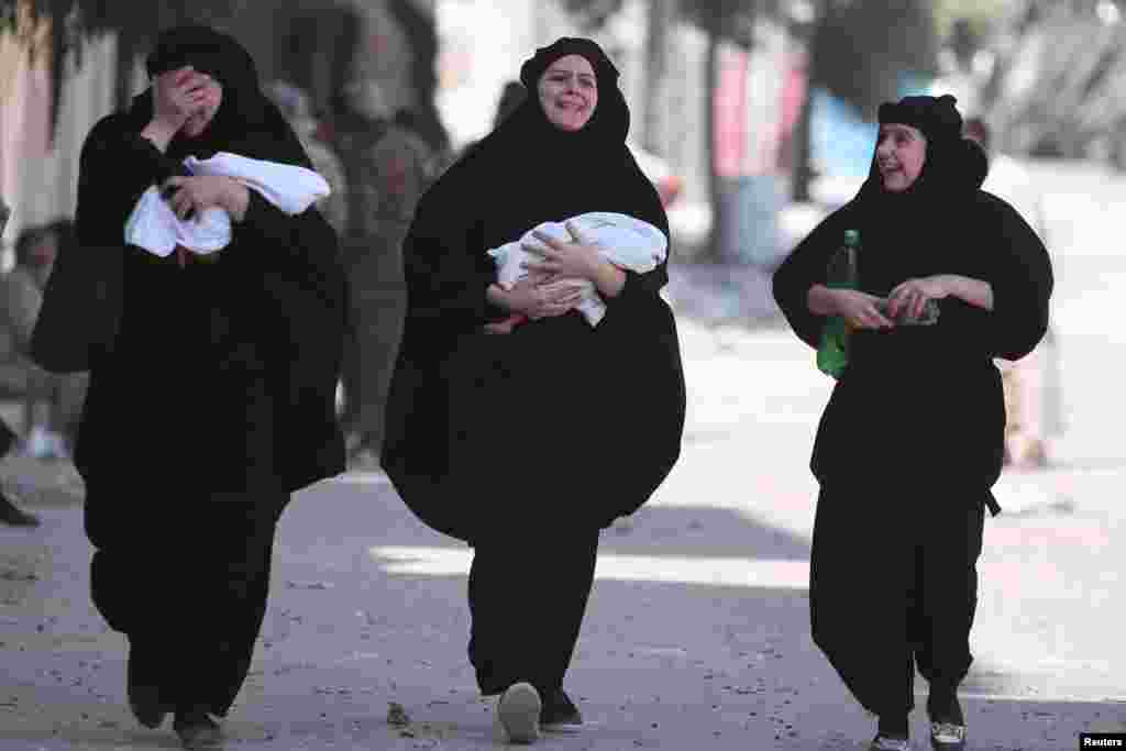 Ibu-ibu menggendong bayi mereka yang baru lahir dievakuasi bersama yang lainnya oleh Pasukan Demokratis Suriah (SDF) dari kota Manbij yang dikuasai ISIS di Aleppo, Suriah (12/8). (Reuters/Rodi Said)
