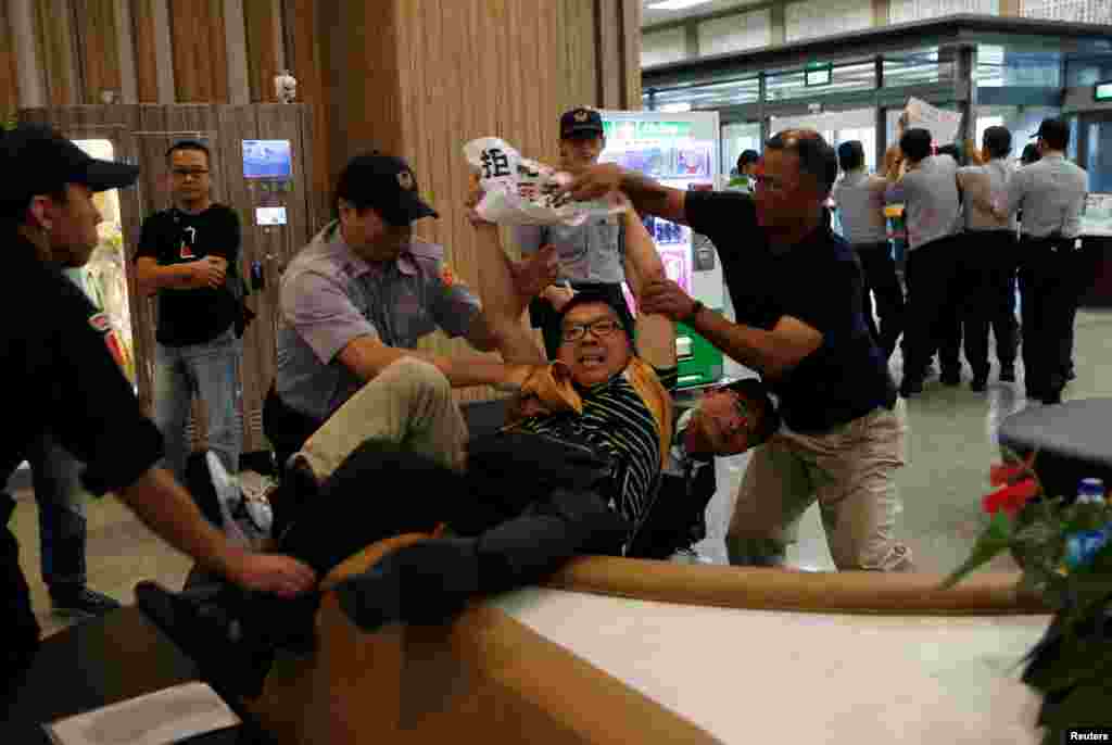 Anti-China demonstrators are stopped by police as Sha Hailin, a member of Shanghai’s Communist Party standing committee, arrives for a forum at Songshan Airport in Taipei, Taiwan.