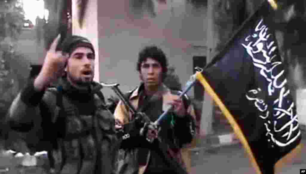 This image taken from video shows a Free Syrian Army fighter speaking in front of a government intelligence complex in Deir el-Zour, Syria, January 29, 2013. (Ugarit News)