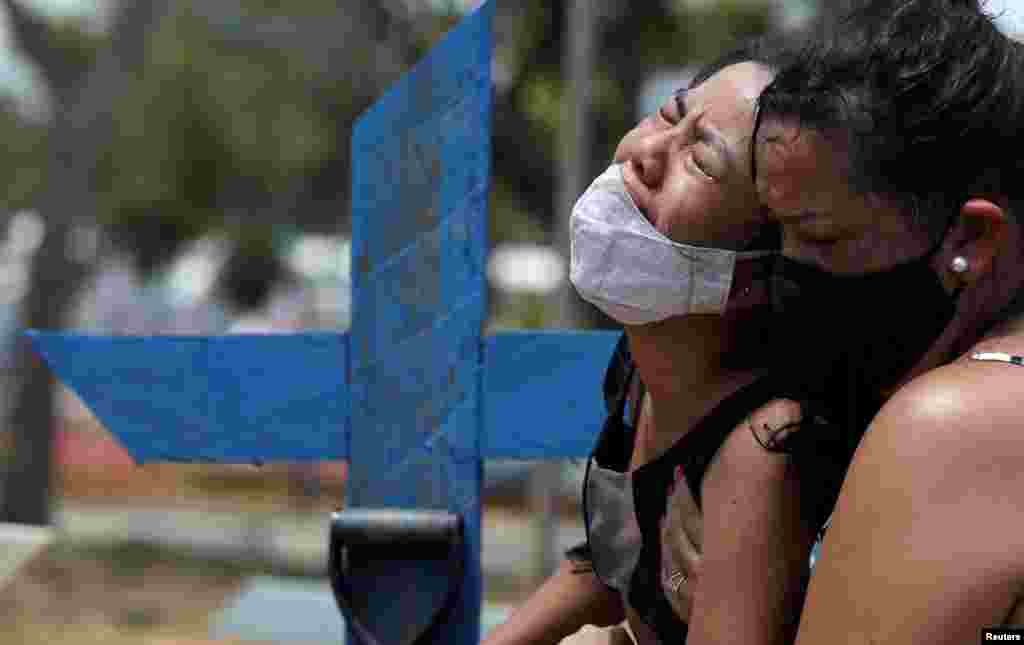 Kelvia Andrea Goncalves is comforted by her aunt Vanderleia dos Reis Brasao, at the Parque Taruma cemetery in Manaus, Brazil, Jan. 17, 2021, during the burial of her mother Andrea dos Reis Brasao, 39, who passed away due to the COVID-19 at Delphina Aziz hospital.