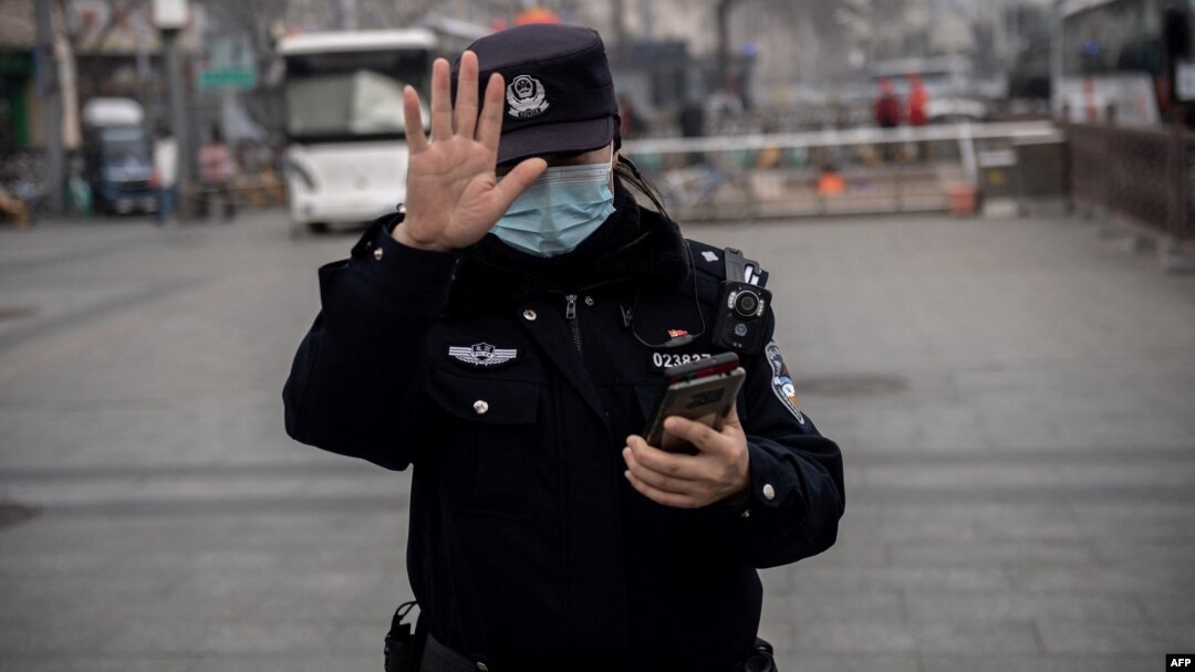 Arhiva - Policajka gestikulira tokom otvarajuće sednice Nacionalnog narodnog konresa u Pekingu, 5 marta 2021.