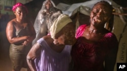 Las personas afectadas por el terremoto del sábado se encuentran bajo la lluvia de Tropical Depression Grace en un campo de refugiados en Les Cayes, Haití, el lunes 16 de agosto de 2021.
