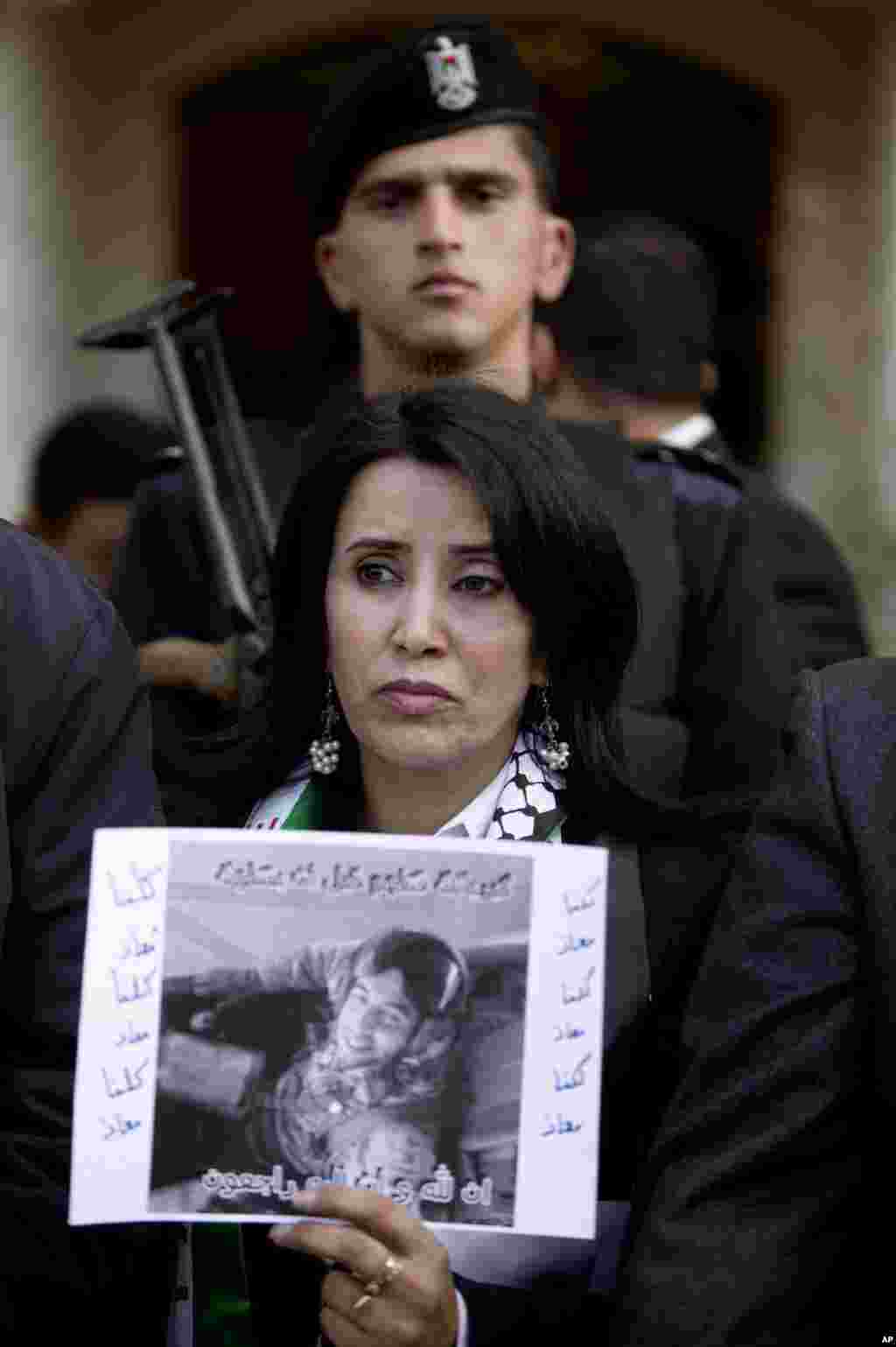 Một phụ nữ Palestine cầm ảnh phi công bị giết Muath al-Kaseasbeh trong cuộc biểu tình trước đại sứ quán Jordan ở thành phố Ramallah, ngày 4/2/2015.