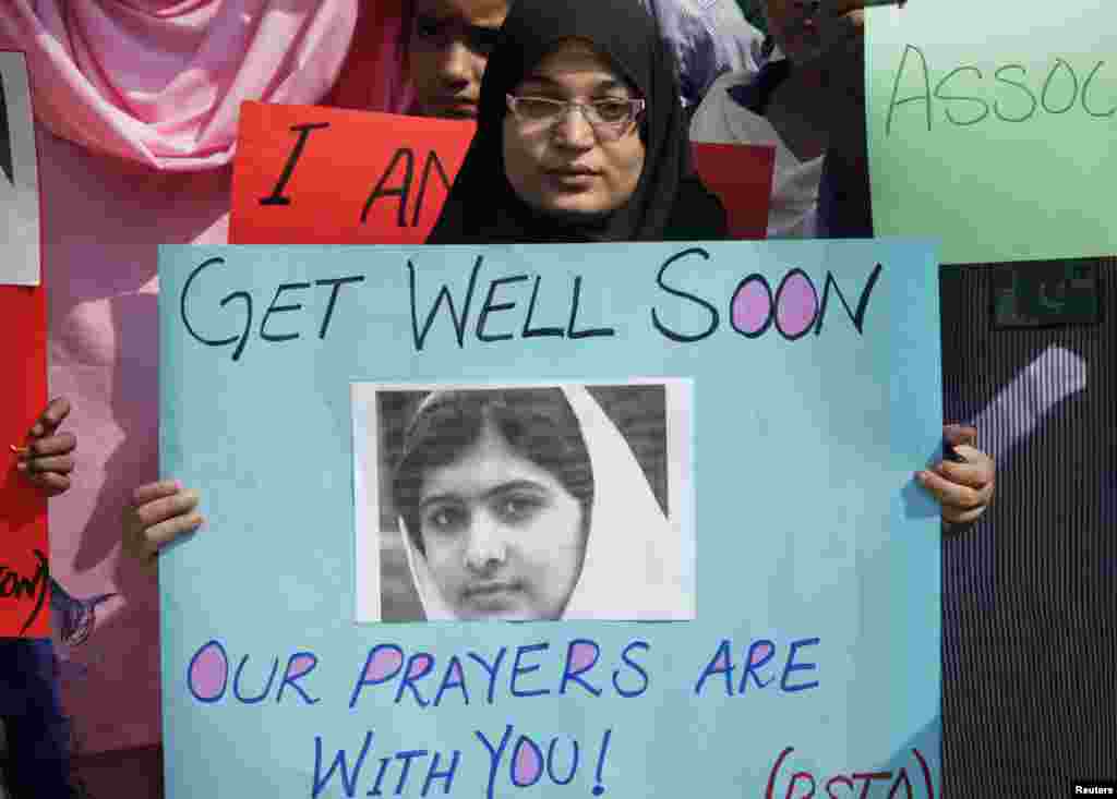 Một học sinh Pakistan cầm hình ảnh của nữ sinh Malala Yousufzai trong cuộc tuần hành ở Lahore, ngày 16/10/2012