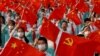 资料照：2021年7月1日中国共产党建党100周年纪念彩排活动表演者手举五星旗和中共党旗。