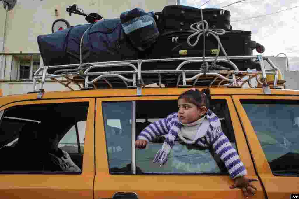 A girl looks out of the window of a vehicle while waiting at the Rafah border crossing's departure area to travel from the Gaza Strip into Egypt, which reopened after Egypt announced to let through incoming traffic until further notice. 