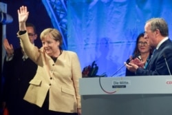 Kanselir Jerman Angela Merkel melambai di samping pemimpin Uni Demokratik Kristen (CDU) dan kandidat teratas untuk kanselir Armin Laschet selama rapat umum pemilihannya di Stralsund, Jerman, 21 September 2021. (Foto: Reuters)