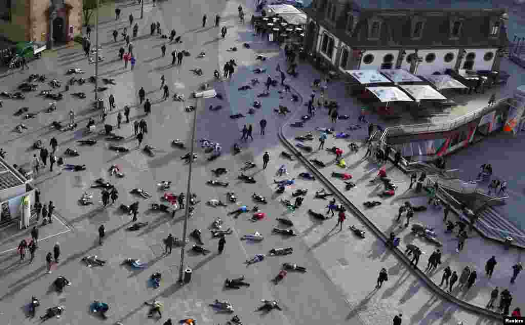 Beberapa orang berbaring di lapangan kota Frankfurt, Jerman untuk mengenang 528 korban pembantaian di kamp konsentrasi Nazi "Katzbach" di Jerman.