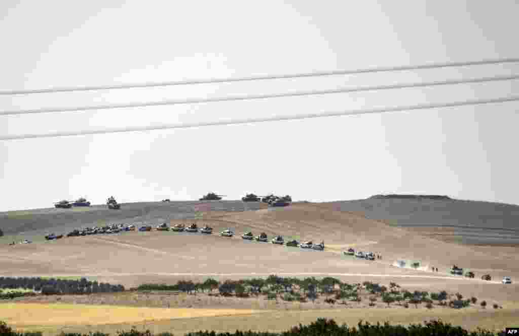 This picture, taken from the Turkish-Syrian border city of Karkamis in the southern region of Gaziantep, shows Turkish army tanks and pro-Ankara Syrian opposition fighters moving two kilometers west from the Syrian Turkish border town of Jarabulus. Turkey's army backed by international coalition air strikes launched an operation to drive Islamic State jihadists out of a key Syrian border town.