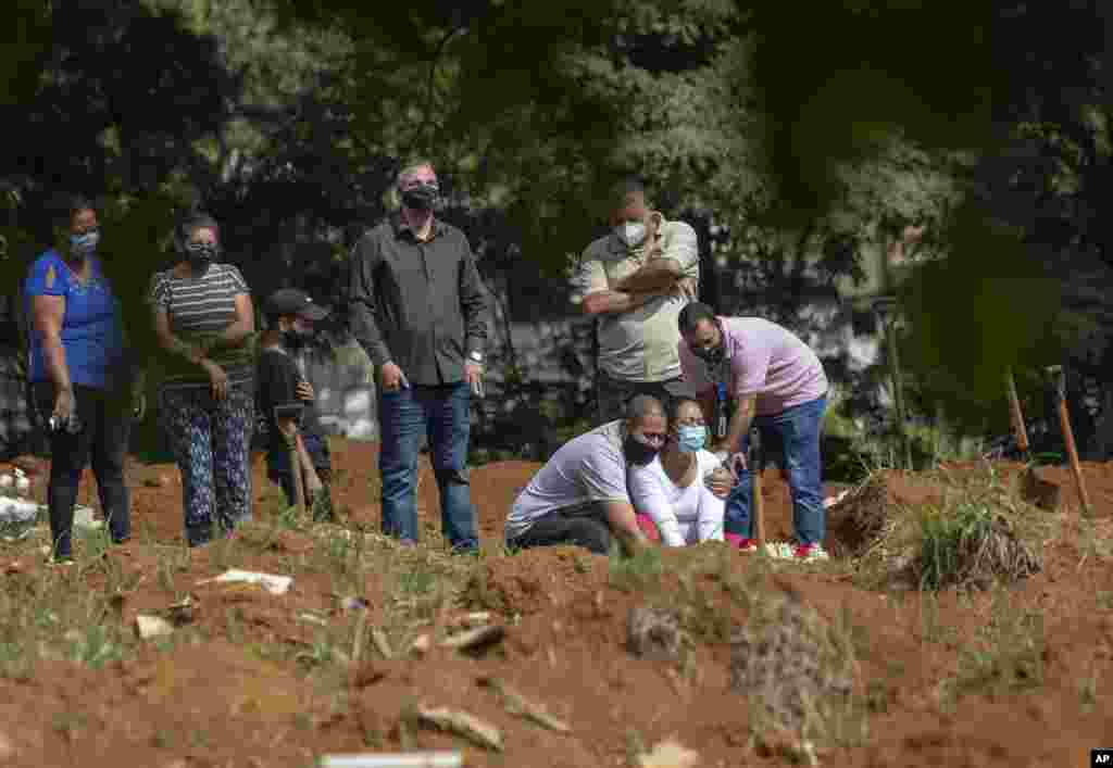 Relatives grieve as they attend a burial service of a person who died from complications related to COVID-19 at the Vila Formosa cemetery in Sao Paulo, Brazil.