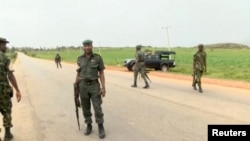 FILE - A still image taken from a video shot on June 25, 2018, shows security officers on the street in Plateau, Nigeria. 