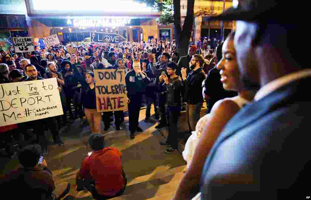 Siedric, à direita,e Sadio White, saem de um hotel durante a sua festa de casamento para observar os manifestantes na rua que protestam contra a eleição de Donald Trump como Presidente dos EUA, em Atlanta. Nov. 11, 2016.