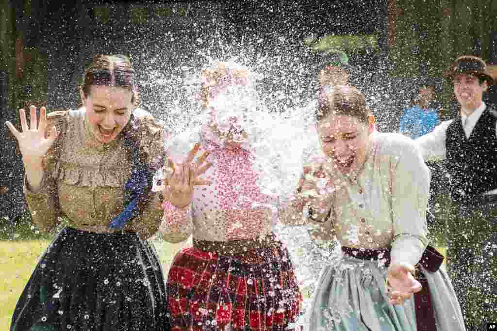 Para perempuan dengan pakaian tradisional disemprot dengan air saat perayaan Paskah di Nyiregyhaza, timur laut Budapest, Hungaria.