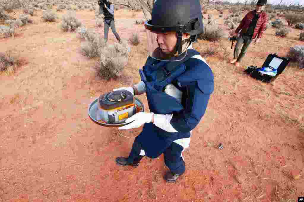 In this photo provided by the Japan Aerospace Exploration Agency (JAXA), a member of JAXA retrieves a capsule dropped by Hayabusa2 in Woomera, southern Australia.