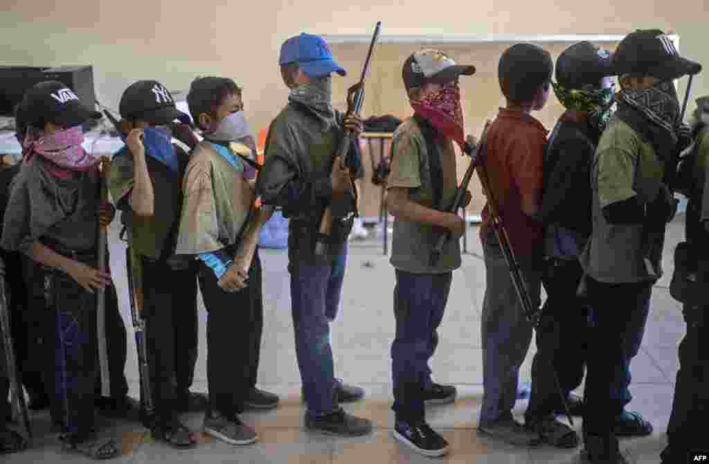 Children holding toy weapons and wooden sticks, take part in a training demonstration of the Regional Coordinator of Community Authorities (CRAC-PF) vigilante force, in the village of Ayahualtempa, Guerrero State, Mexico. The vigilante group trains children as young as five so they can protect themselves from drug-related criminal groups operating in the area, according to their leaders.
