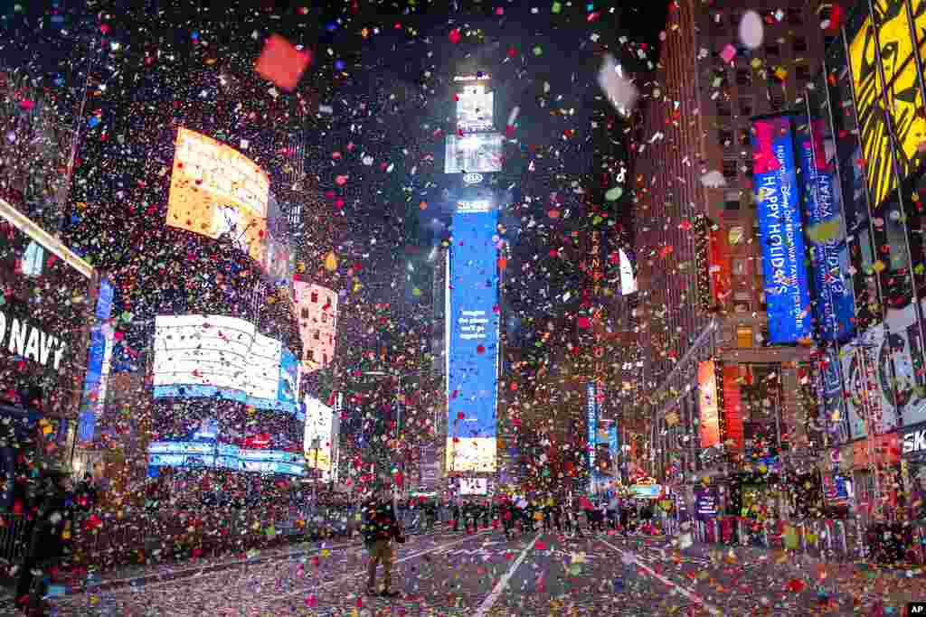 Confetti flies after the Times Square New Year's Eve Ball drops in a nearly empty Times Square, as the area normally packed with revelers remained closed off due to the ongoing coronavirus pandemic.