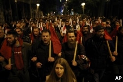 Members of the Communist Party-affiliated labor union shout slogans during a rally in Athens, Jan. 15, 2018. Greek lawmakers, eying the end of eight years of bailout programs, approved more painful austerity measures late Monday, as strikes and mass protests brought much of Athens to a standstill.